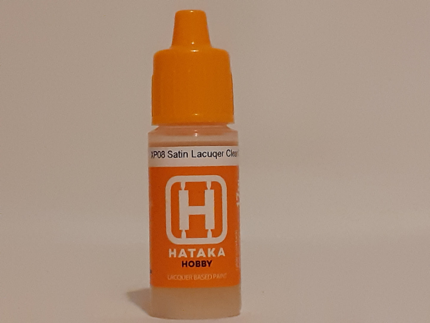 A 17ml bottle of Hataka Satin Lacquer Clear Coat with an orange cap and label, designed for use with airbrush painting techniques.
