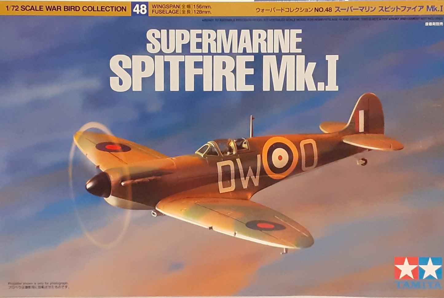 A Tamiya 1:72 scale model kit of the Supermarine Spitfire Mk.I, featuring the aircraft in flight with a cloud-filled sky in the background.