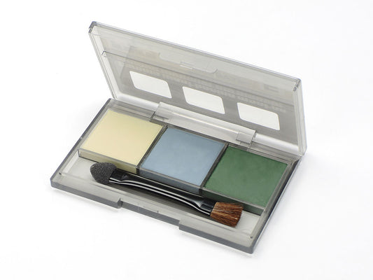 A set of Tamiya weathering master pigments with a brush, including yellow, gray, and green shades, displayed in a clear plastic case.